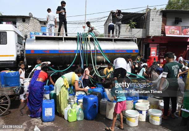 People collect water from a municipal tanker of Delhi Jal Board on a hot summer day as water crisis continues, amid ongoing water crisis at Sanjay...