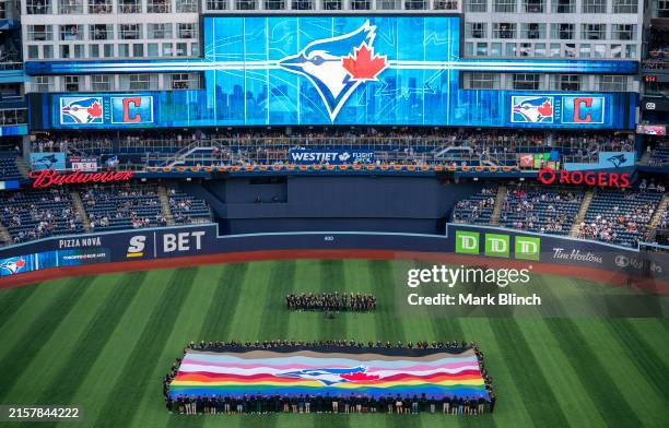Pride themed flag is displayed in the outfield to honor Pride Night before the Toronto Blue Jays play the Cleveland Guardians in their MLB game at...