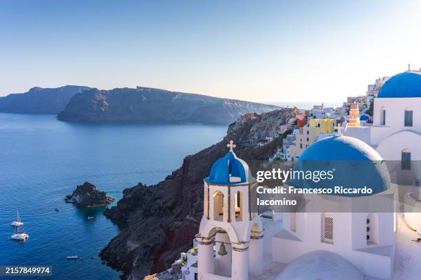 oia, santorini island, cyclades, greece. cityscape, houses and churches with bell, sea on background - aegean sea stock pictures, royalty-free photos & images