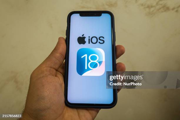 The Apple logo is seen with the iOS 18 operating system logo on a mobile device in this illustration photo taken in L'Aquila, Italy, on June 20th,...