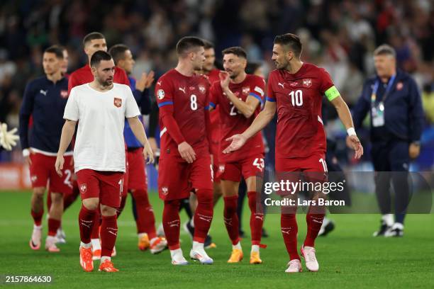 Dusan Tadic of Serbia speaks with teammates as he reacts after defeat to England during the UEFA EURO 2024 group stage match between Serbia and...