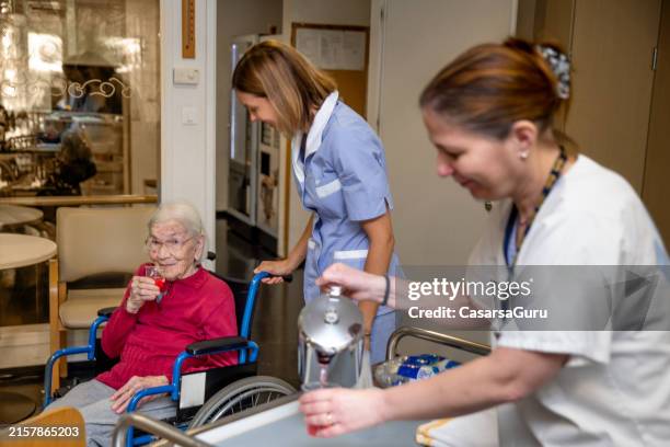 caregivers serving tea in a nursing home - meals on wheels stock pictures, royalty-free photos & images