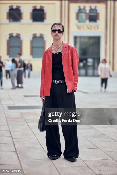 Guest wears vintage tank top in black and Barrett red leather jacket with beggy jean outside Neil Barrett show during the Milan Fashion Week Menswear...