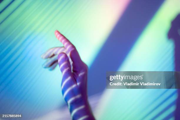 hand covered in colorful light patterns - sparse people stock pictures, royalty-free photos & images