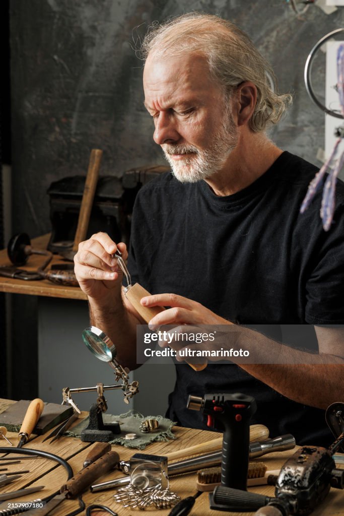 Man jeweler, produces hand made a ring. Jeweler craft workshop