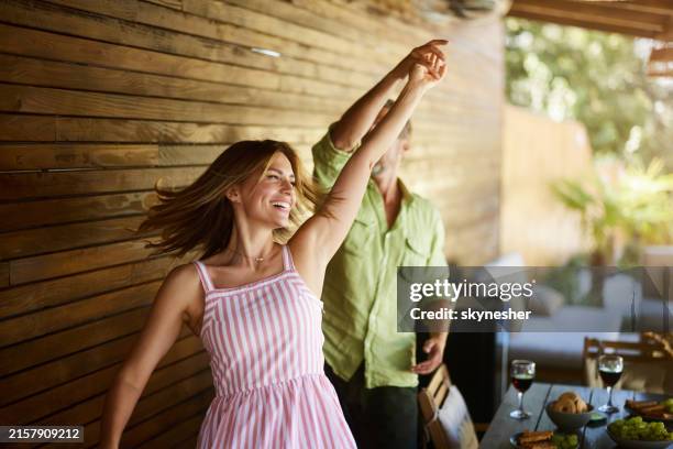 carefree couple having fun while dancing on a patio. - spring food stock pictures, royalty-free photos & images