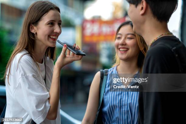 foreign tourist using ai translation apps to communicate with locals - assistente-virtual imagens e fotografias de stock