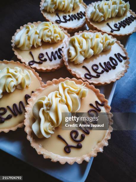 plate of lemon tarts on dark table top - pastry lattice stock pictures, royalty-free photos & images