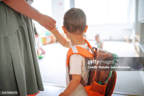 asian toddler arriving at kindergarten with mom, starting adjustment to new children's group - peuterschool gebouw stockfoto's en -beelden