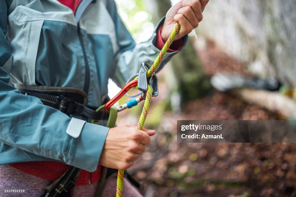 Caucasian Female Belayer Securing Climber's Rope