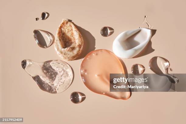 different cosmetic textures on a delicate peach background. - collagen stock pictures, royalty-free photos & images