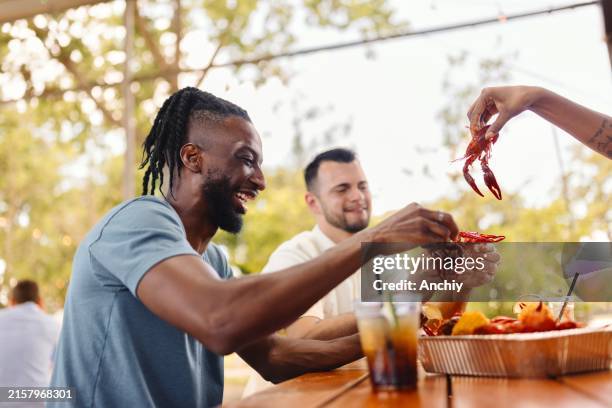 close-up of people eating crawfish at the restaurant outdoors - cajun people of photos et images de collection