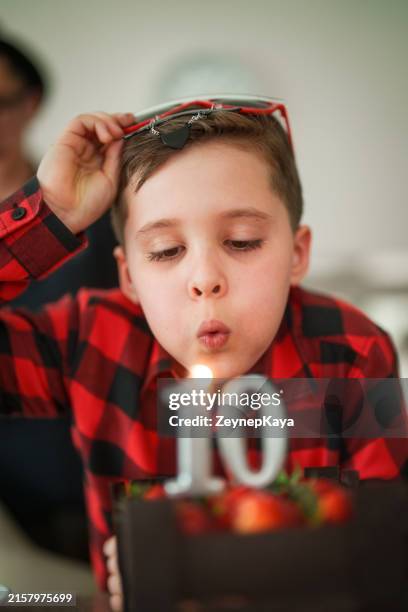 kid is blowing number 10 birthday candles. - 10 11 jahre stock-fotos und bilder