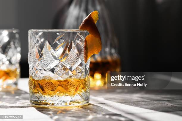 cocktail drinks glasses, whiskey on the rocks and decanter and hard shadows from copy space - brandy stock pictures, royalty-free photos & images