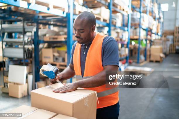 warheouse worker sealing a delivery box - drop shipping stock pictures, royalty-free photos & images