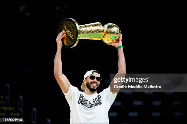 Jayson Tatum of the Boston Celtics hoists the Larry O'Brien trophy as he is introduced during the Boston Celtics Victory Event following their 2024...