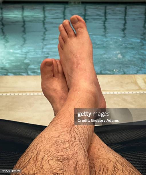 view of a man's legs reclining at the edge of a swimming pool - feet in the bath stock pictures, royalty-free photos & images
