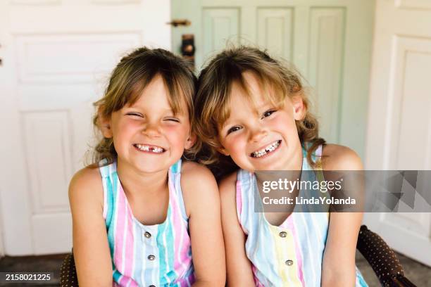 twin girls with missing teeth - portrait of a young girl with gappy teeth and blond hair stock pictures, royalty-free photos & images