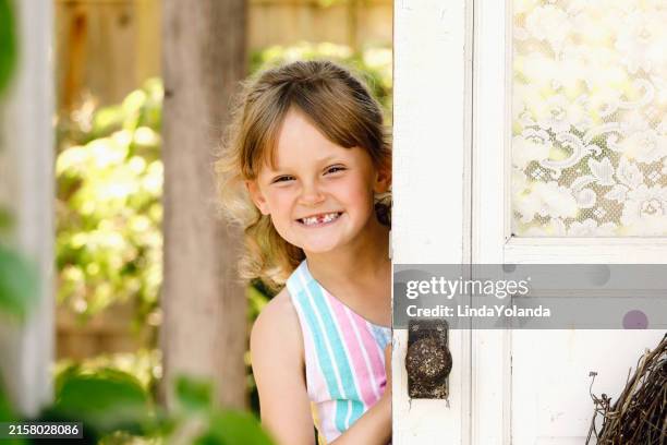 little girl in garden - portrait of a young girl with gappy teeth and blond hair stock pictures, royalty-free photos & images