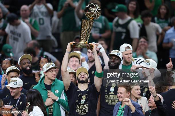 Jayson Tatum of the Boston Celtics lifts the Larry O’Brien Championship Trophy after Boston's 106-88 win against the Dallas Mavericks in Game Five of...