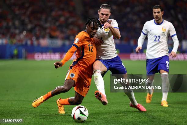 Netherlands' forward Jeremie Frimpong fights for the ball with France's midfielder Adrien Rabiot during the UEFA Euro 2024 Group D football match...