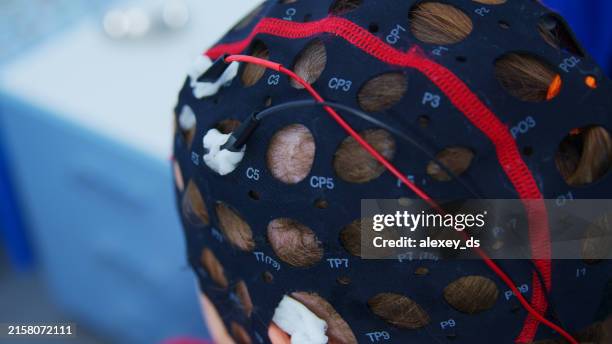 eeg cap is weared to provide brain activity test - electrode stock pictures, royalty-free photos & images
