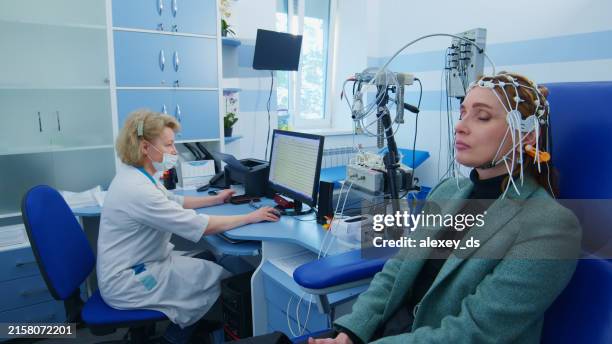 woman undergoing eeg test in medical office - neurologist stock pictures, royalty-free photos & images