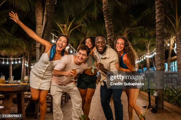 joyful friends with refreshments at beachside gathering - organized group photo stock pictures, royalty-free photos & images