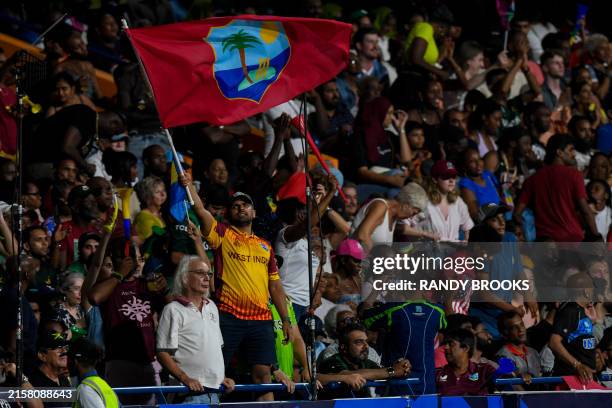 Supporters of West Indies wave a flag during the ICC men's Twenty20 World Cup 2024 Super Eight cricket match between USA and West Indies at...