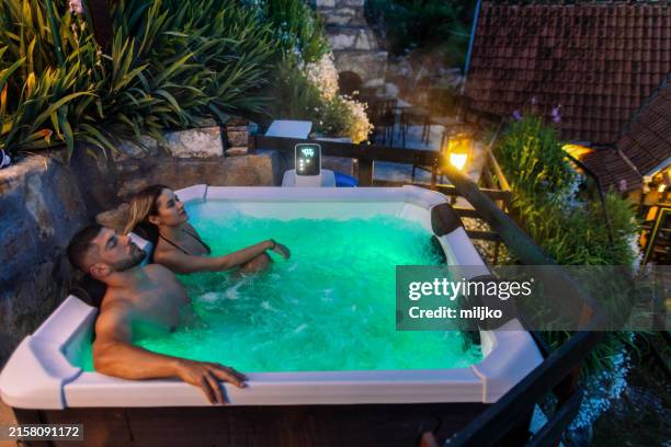 pareja relajándose en jakuzzi - bañera caliente fotografías e imágenes de stock
