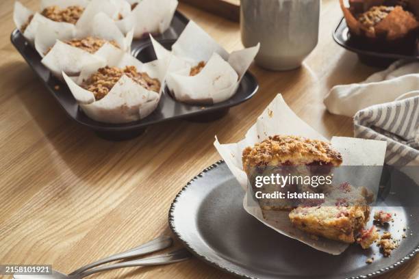 halved muffin with fresh raspberries and streusel topping on kitchen table, delicious breakfast - papel de cera imagens e fotografias de stock