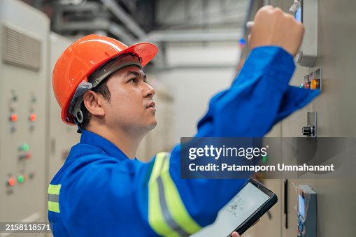 Power Engineer Utilizing Tablet for Real-Time Data in Control Room. Digital technology in maintaining and improving power systems. Power Engineer Utilizing Tablet for Real-Time Data in Control Room. Digital technology in maintaining and improving power systems.