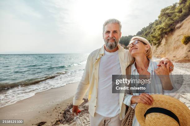 senior-paar genießt den tag am strand - pensionisten stock-fotos und bilder