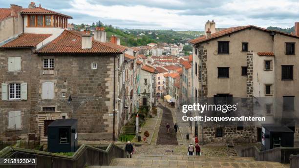 view of the city of le puy, velay, france, as seen from the entrance of the cathedrale notre dame - auvergne stock pictures, royalty-free photos & images
