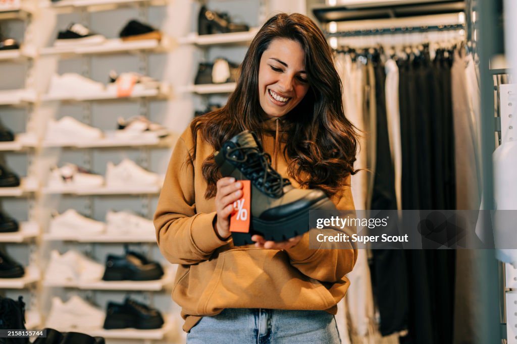 Schöne junge Frau, die versucht auf Schuhe