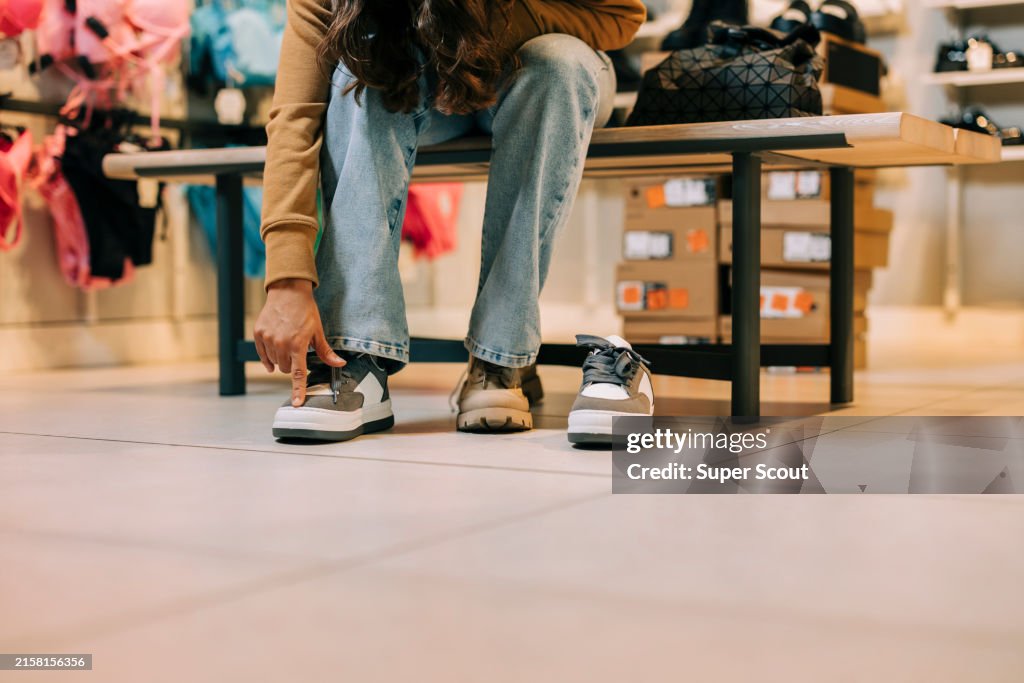 Beautiful young woman trying on shoes