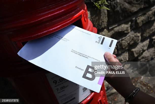 An envelope containing a Postal Vote for the upcoming UK General Election is posted in Birkenhead, north west England on June 22, 2024.