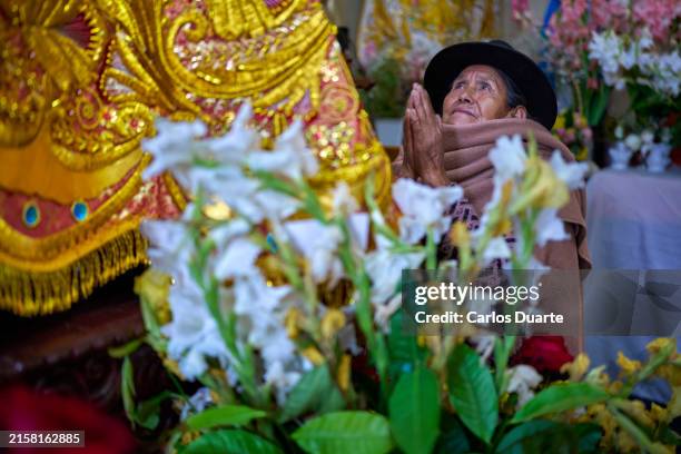 mujer peruana de la etnia quechua mostrando su fe rezando en una iglesia detrás de la virgen maría - peru face fotografías e imágenes de stock