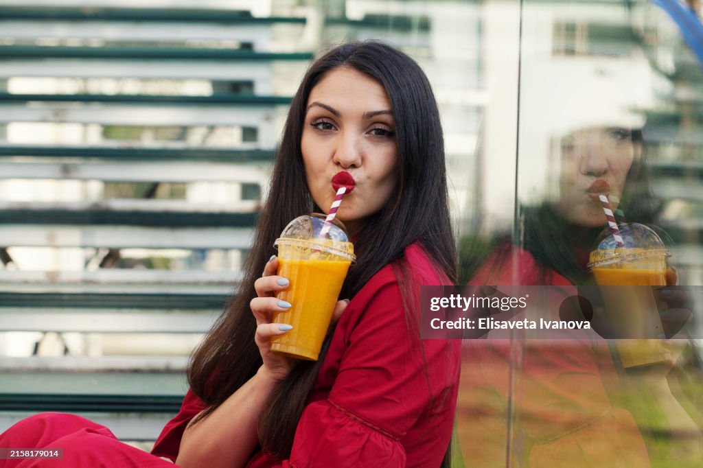 Beautiful young woman drinking orange juice