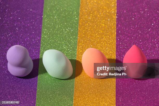 colorful makeup egg sponges beauti blender on glittering background - beauti stock pictures, royalty-free photos & images