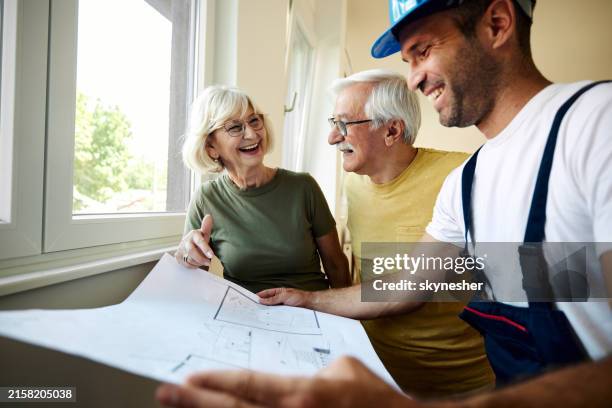couple de personnes âgées heureuses analysant les plans de logement avec un travailleur manuel. - rénovation photos et images de collection