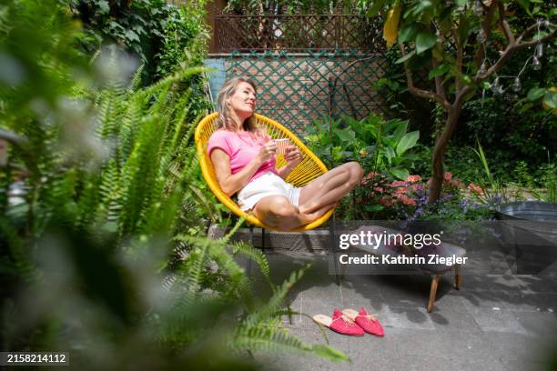 woman enjoying a healthy breakfast by herself in the garden - sunbathing stock pictures, royalty-free photos & images