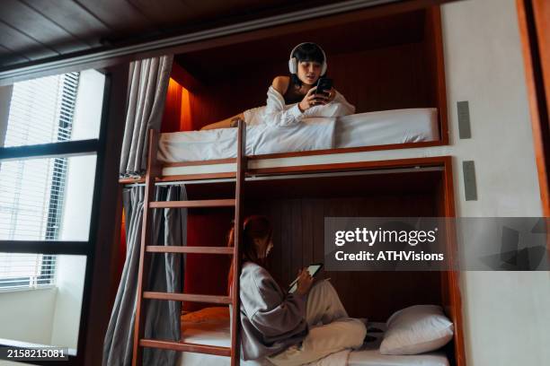friends relaxing in bunk beds at hostel - budget travel stock pictures, royalty-free photos & images