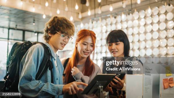 group of friends using a self check-in kiosk at a hostel, emphasizing travel, technology, and convenience in a modern accommodation setting. - self service stockfoto's en -beelden