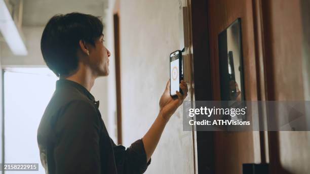 hostel-mitarbeiter entsperren mit smartphone ein hostel-türzimmer - hotelzimmer tür stock-fotos und bilder