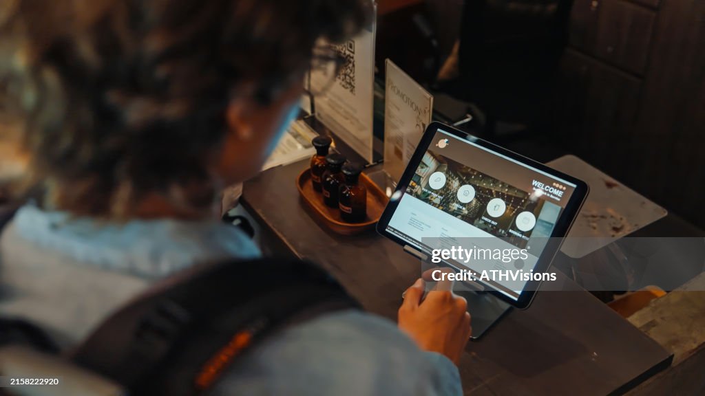 Friends Using Self Check-In on tablet at Hostel