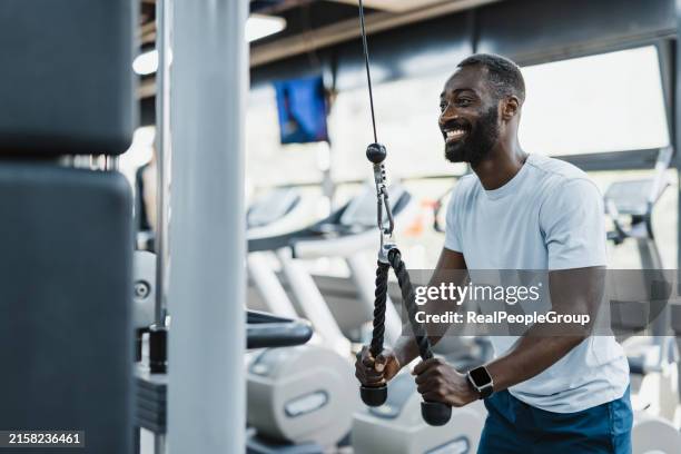 uso de la máquina de cable en el gimnasio moderno - culturismo fotografías e imágenes de stock