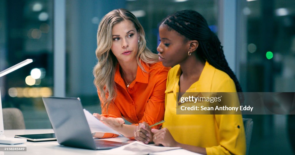 Team diversity, overtime and women in office with documents, talking and discussion at night. Teamwork, late work and female partners in boardroom for strategy, corporate project and technology