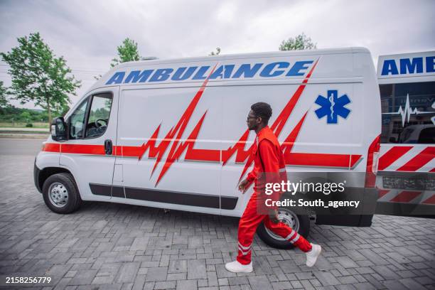 paramedic walking by ambulance - openbare dienstverlening stockfoto's en -beelden