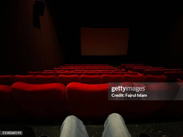 one person at theater seats - green screen movie stock pictures, royalty-free photos & images
